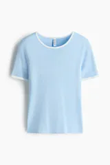 Remera de punto fino color celeste, entallada, de manga corta, con ribetes acanalados blancos en el cuello redondo, puños y dobladillo.