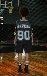 Camiseta estilo jersey de fútbol americano, color negro, con cuello en V ribeteado en blanco y dorado. Presenta el número "90" grande en el frente con borde blanco y dorado. Tiene inscripciones bordadas en el pecho como "L.A." y "Ravers", y el número "9" en la manga.