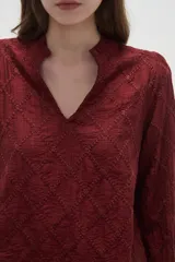 Blusa de viscosa color bordó con diseño bordado geométrico, cuello en V y mangas largas con terminación en volados.