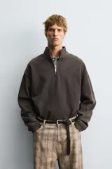 Sudadera de corte boxy fit con cuello subido y cierre frontal de cremallera. Presenta mangas largas, acabado efecto lavado y puños y ruedo en rib.