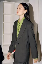 Camisa oversize verde de popelina de algodón, con cuello solapa, manga larga y cierre frontal con botones ocultos bajo solapa.