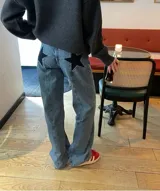 Pantalón de jean celeste con parches de estrellas negras en los laterales.