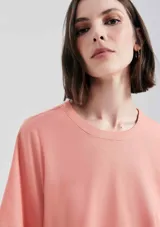 Blusa manga corta de tejido liso, color salmón, con cuello redondo y corte recto.