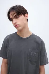 Remera celeste de algodón con bolsillo en el pecho, arte en el bolsillo y bordado en la manga.