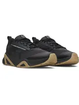 Championes de entrenamiento Under Armour Charged Commit TR 5, color negro con detalles en color tostado en la suela y entresuela, y la marca visible en el lateral. Confeccionados con malla transpirable y revestimientos de cuero.