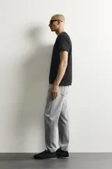 Jeans de corte slim cropped confeccionados en denim de algodón rígido con efecto lavado. Presentan tiro medio, cierre frontal con cremallera y botón, y diseño clásico de cinco bolsillos.