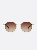 Lentes de sol Carolina Lemke con montura dorada y lentes marrones degradé.