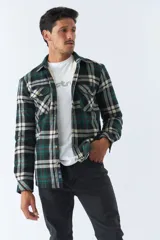 Sobrecamisa de algodón a cuadros color ladrillo, con interior de corderito, cierre con botones, bolsillos tipo cartera y logo en goma. El modelo usa talle M.