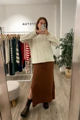 Sweater tejido color arena con diseño de espiga, cuello redondo y mangas largas.