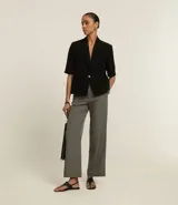 Pantalón recto de vestir color gris, de corte sastrero con cintura alta, trabillas y detalle de ganchillo en la cintura.