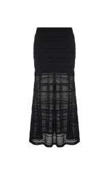 Pollera midi de punto color negro, con diseño calado y franjas horizontales de diferentes texturas. Presenta un corte entallado que se ensancha ligeramente hacia el ruedo.