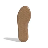 Championes Adidas modelo Barreda Decode, de diseño urbano inspirado en el fútbol tradicional. Presentan una combinación de tonos marrones con las icónicas tres bandas laterales en color crema. Cuentan con puntera en T, empeine textil y de piel, y una distintiva suela de goma translúcida.