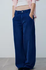 Pantalón de tiro medio confeccionado en pana color azul, de corte baggy con pierna ancha, estilo clásico de cinco bolsillos y cierre frontal con cremallera y botón metálico.
