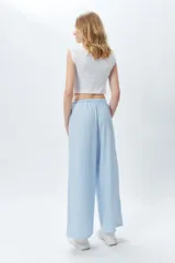 Pantalón largo de tela rayada celeste y blanco, con cintura elástica.