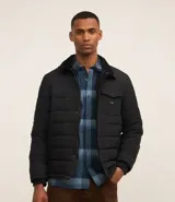 Campera puffer negra con cuello alto, cierre frontal con botones a presión, bolsillos laterales y un bolsillo cargo en el pecho. Presenta un diseño acolchado y forro interior suave.
