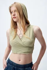 Top cropped negro con capucha, escote cruzado y calce ceñido.