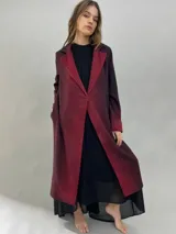 Tapado de paño de lana con diseño de solapas amplias, corte recto y bolsillos laterales ocultos. Presenta un degradado de color que va desde un tono bordó intenso en las solapas y puños hacia un tono más oscuro en el cuerpo.