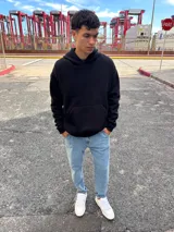 Canguro negro con capucha, de corte holgado y manga larga. Presenta un estampado gráfico en la espalda con el texto 'Community of talented people' y 'SOUTH CAPITAL' junto a iconos minimalistas.