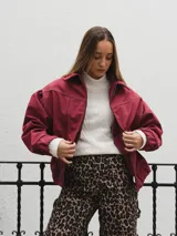 Campera gris con cierre frontal, cuello camisero y mangas largas con puños elásticos.