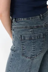 Pantalón de jean celeste con corte acampanado, tiro alto y costuras verticales al frente.