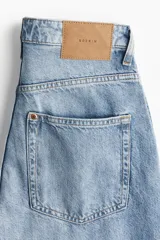 Pantalón de jean celeste de tiro alto, corte holgado en cintura, cadera y muslos, con estilo baggy de muslo a bajo.