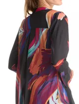 Túnica larga de gasa con estampado abstracto multicolor sobre base negra, cuello a la base, cierre frontal con botones y mangas largas con puños amplios.