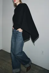 Capa de punto color marrón, con cuello redondo y diseño holgado de caída fluida.