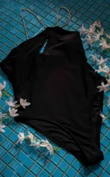 Traje de baño enterizo blanco con breteles finos y abertura en el pecho.