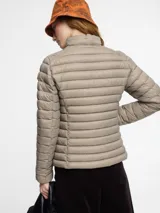 Campera acolchada Save The Duck modelo Carly, color verde militar, confeccionada en nylon y rellena con Plumtech. Cuenta con cuello alto, cierre bidireccional, bolsillos laterales con cierre y logo redondo de goma en la manga izquierda.