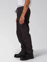 Pantalon utilitario color negro lavado, confeccionado en tejido elástico. Presenta cintura elástica con cordón de ajuste, bolsillos laterales de entrada, bolsillo utilitario en la pierna derecha y bragueta falsa.