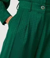 Pantalón pantalona verde esmeralda de jacquard con botones diferenciados en la cintura.