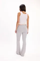 Pantalón calza gris melange de corte flare, tiro alto con cintura rebatible ancha y ajuste entallado en las piernas que se ensancha hacia los tobillos.