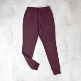 Pantalón de jogging color bordó, con cintura elástica ajustable con cordón y puños en los tobillos.