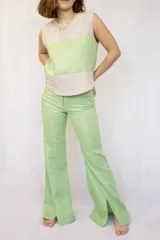 Pantalón verde claro de lino, de corte recto y con aberturas en el ruedo.