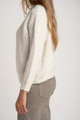Sweater de punto texturado en color beige melange con motas de colores, diseño oversize, cuello alto con cierre frontal y mangas largas.