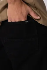 Jean mom de corte holgado color negro, confeccionado en denim de algodón con diseño clásico de cinco bolsillos y tiro medio.