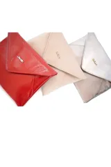 Sobre de fiesta tipo clutch en cuero charol color rojo, con diseño de solapa triangular y cierre magnético. Incluye una cadena metálica fina para llevar al hombro o como bolso de mano.