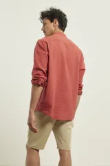 Camisa de cuello mao y manga larga, confeccionada en una mezcla de lino y algodón. Presenta un diseño de corte recto con botones en tono natural y un bolsillo pequeño en el pecho.