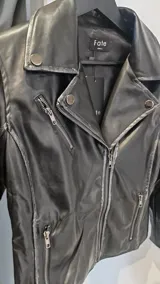 Campera rockera de símil cuero semi desgastado, con solapas amplias, cierre cruzado y bolsillos frontales con cierre.