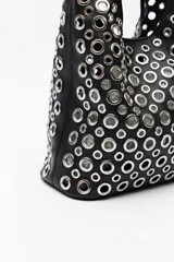 Cartera negra estilo hobo con apliques metálicos plateados en toda su superficie.