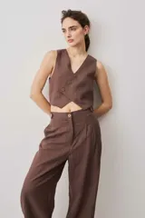 Chaleco cropped color chocolate con escote en V y diseño de cierre cruzado asimétrico con botones.