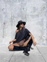 Short de tiro medio confeccionado en ecocuero, con bolsillos delanteros y cierre frontal con botón metálico.