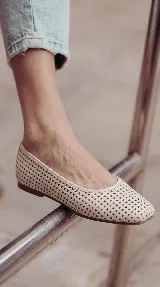 Chatita de cuero color off-white, con diseño calado en toda su superficie y punta redondeada.