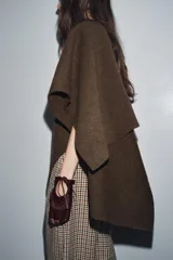 Guantes tipo mitones confeccionados en piel con acabado efecto pelo. Presentan un diseño sin dedos, con una abertura circular en el dorso ajustada mediante una lazada del mismo material.