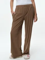 Pantalón de dormir de corte recto y tiro medio, confeccionado en tejido suave con textura acanalada. Presenta cintura elástica y bolsillos laterales.