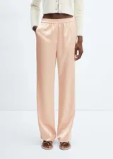 Pantalón de corte recto y diseño fluido con efecto satinado. Presenta cintura con elástico y dos bolsillos laterales.