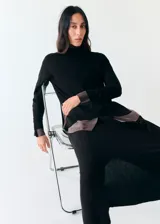 Falda midi negra de punto, de corte recto y tiro alto, con detalle de lazo ajustable en la cintura.