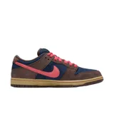 Championes Nike SB Dunk Low con diseño de paneles en gamuza azul marino y marrón, acentuados con un swoosh y cordones en color rosa vibrante, sobre una suela de goma en tono caramelo.