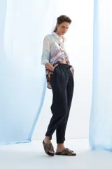 Pantalón de vestir azul marino, de corte recto, con bolsillos laterales y traseros. Se ajusta a la cintura con cinturón de cuero marrón.