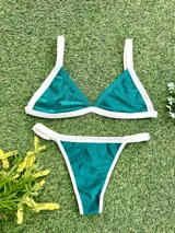 Conjunto de bikini verde esmeralda con ribetes blancos, compuesto por un corpiño triangular fijo con abertura para agregar tazas soft y una bombacha colaless regulable.
